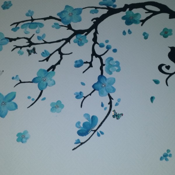 Muurschildering tak met blauwe bloemen