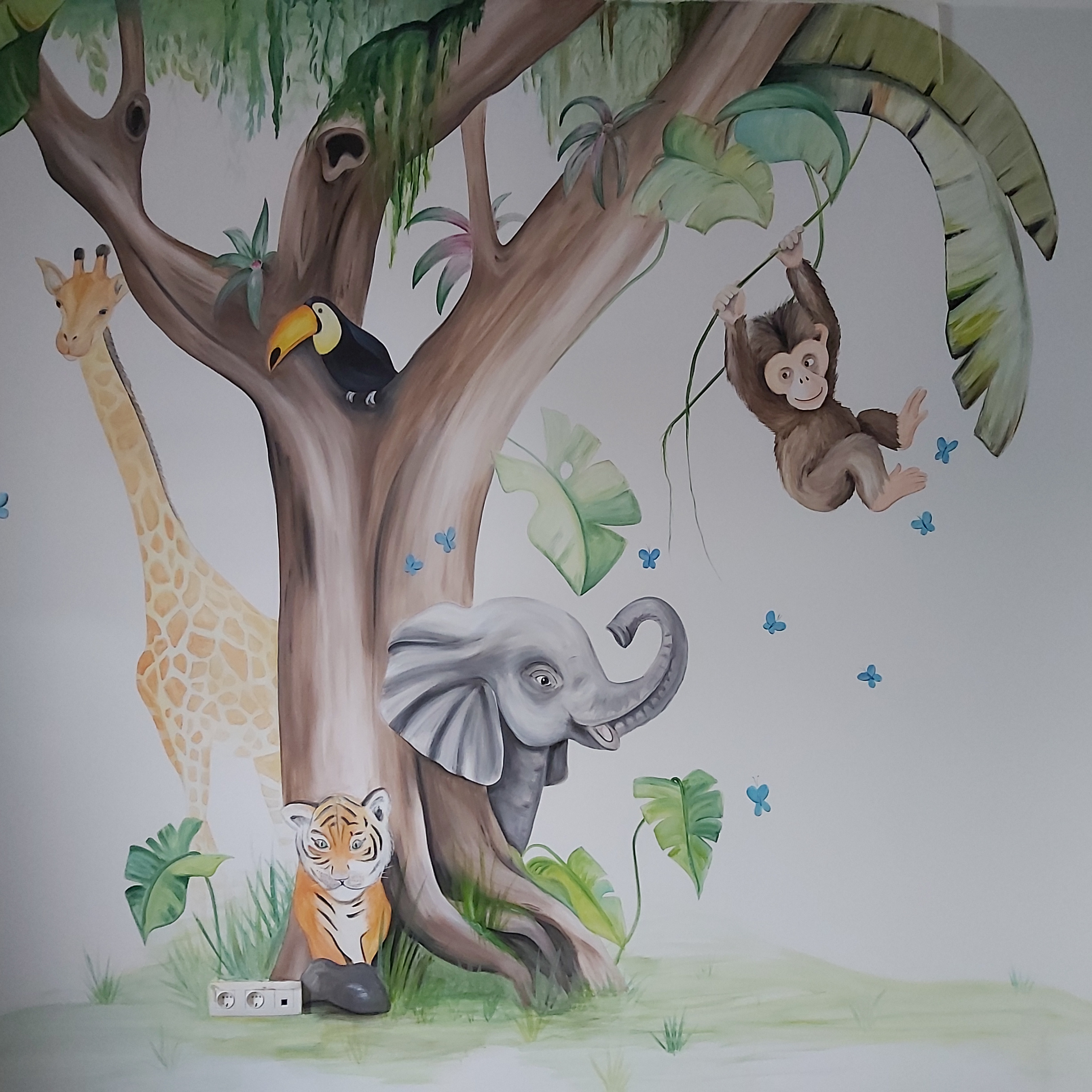 Muurschildering grote boom met veel dieren